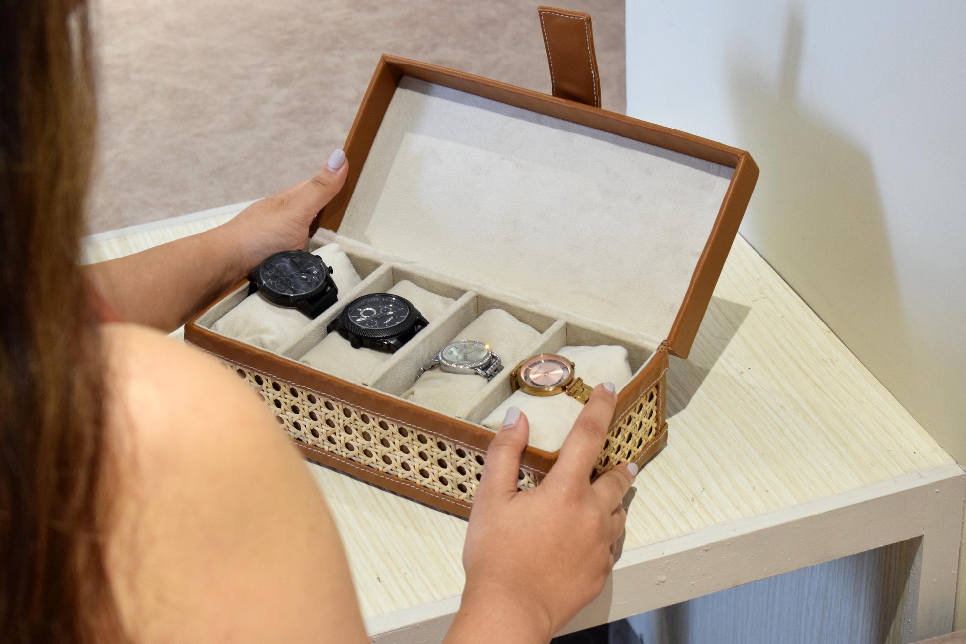 Person holding a cane & leather watch box with watches inside