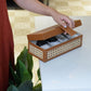  holding a brown wicker watch box with watches displaying watches and magnetic closure 
