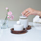 2 marble storage jars with wooden tray and lady holding it 
