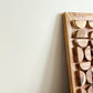 Wooden wall art with circular patterns on a plain background